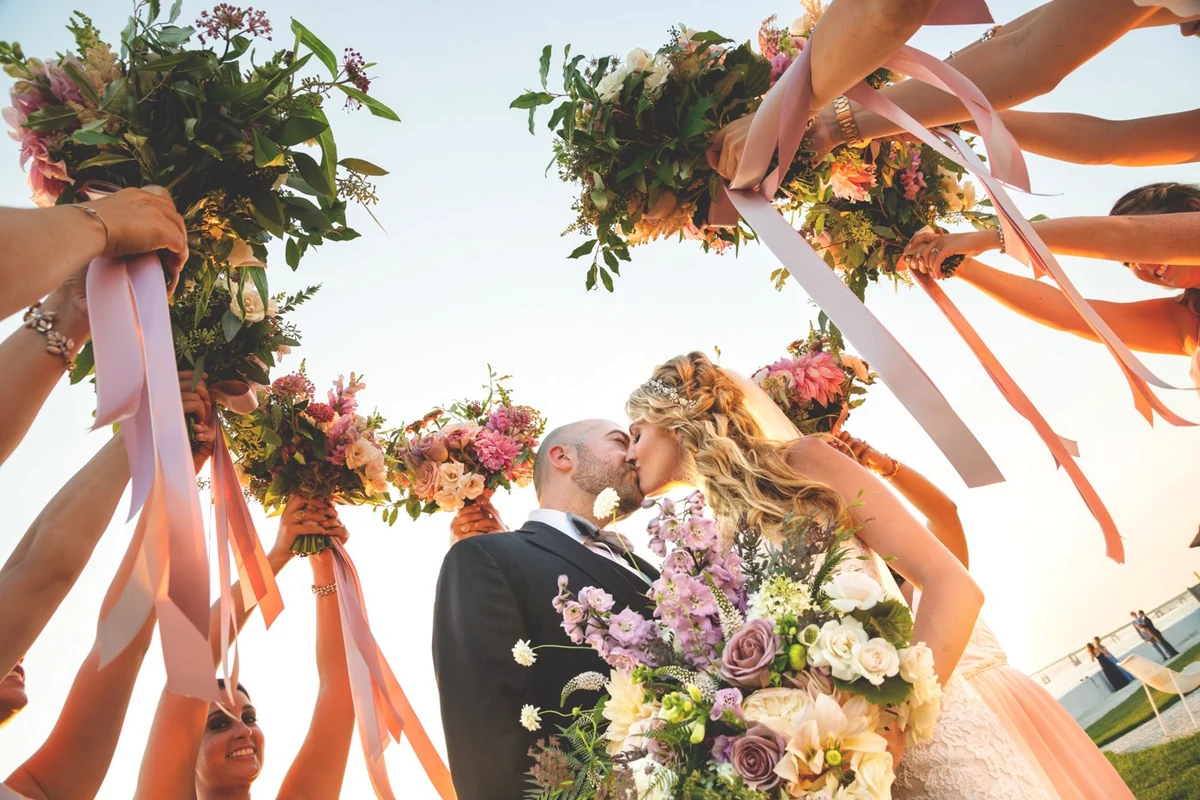 Luxury wedding portrait with bouquets and waterfront light
